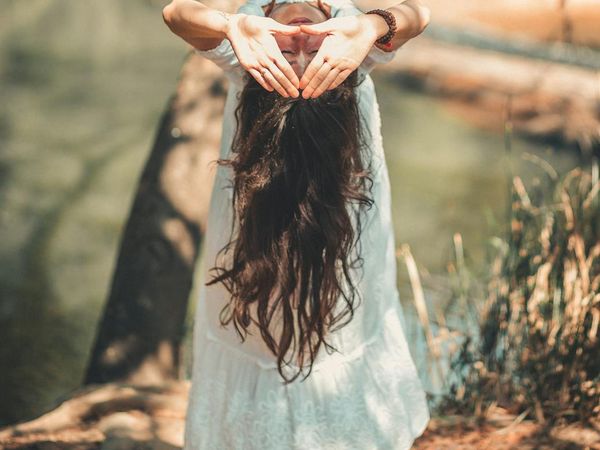 Person meditating in a serene natural environment.